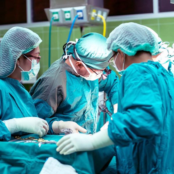 Group of surgeons gathered around operating table performing surgery