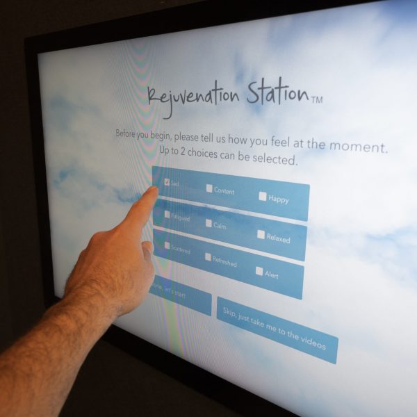 Person pressing survey screen monitor of rejuvenation station